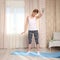 Attractive woman do fitness warming up at home on a blue mat in living room