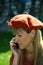 Attractive woman, dressed in orange with hat, talking on the phone