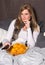 Attractive woman is eating chips and is frightened about television program