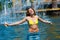 Attractive woman enjoys the cool fountain