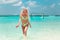 Attractive Woman in fashionable bikini on tropical beach. Pretty slim girl posing on exotic island in turquoise ocean.  Blonde
