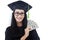 Attractive woman in graduation gown holding money