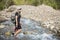 Attractive Woman hiking across a mountain stream