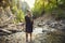 Attractive Woman hiking across a mountain stream on a hike