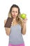 Attractive woman holding apple and chocolate bar in healthy fruit versus sweet junk food temptation