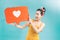 Attractive woman holding heart symbol of like and love social media notification icon happy with followers and fans on the