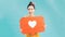 Attractive woman holding heart symbol of like and love social media notification icon happy with followers and fans on the