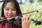 An attractive woman learning musician plays the violin at home. Composer creating songs with string instruments. Dreamy violinist