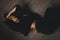 Attractive woman lies on the floor. She looks sensuality. Hot girl wears total black look.