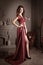 Attractive woman in long claret lace dress