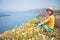 Attractive woman on the meadow full of flowers on Santorini island