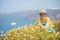 Attractive woman on the meadow full of flowers on Santorini island