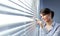 Attractive woman peeking through blinds