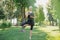 attractive woman practicing yoga in tree pose and making sound with tibetan singing bowl