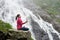 Attractive woman practising yoga on rock near beautiful Balea waterfall in Romania