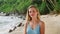 Attractive woman relaxes on sandy beach, serene tropical backdrop with waves. Female in swimwear enjoys sunbath, natural