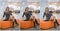 Attractive woman with short dress and long leather boots posing in mall. Beautiful fashionable young girl sitting on orange bench
