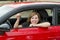 Attractive woman smiling proud sitting at driver seat holding and showing car key in new automobile buying and renting