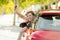 Attractive woman smiling proud sitting at driver seat holding and showing car key in new automobile buying and renting