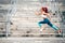 Attractive woman in sportswear exercising outdoors. Portrait of woman jumping and running during cardio training