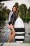 Attractive woman is standing on boat holding rope and wake surf board