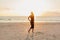 attractive woman standing on ocean beach in sunbeams