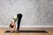 Attractive woman standing in Uttanasana yoga pose against texturized wall
