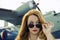 Attractive woman in sunglasses outside near military plane