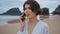 Attractive woman talking mobile phone at shore closeup. Beach lady making call