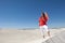 Attractive woman with umbrella on desert sand dune