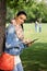 Attractive woman using tablet in park smiling