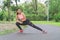 Attractive woman wearing sports warm up before exercise. Sporty female warming up before running in the public park on tree