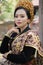 Attractive woman wearing traditional black Balinese kebaya with woven cloth