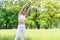 Attractive woman wearing white sports warm up before exercise. Sporty female warming up before running in the public park on