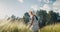 Attractive young adult woman walk through wheat field on sunset at vacation