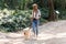 Attractive young amateur photograph woman walking with her dog in the park