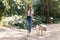 Attractive young amateur photograph woman walking with her dog in the park