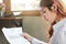 Attractive young Asian business woman looking paperwork or charts on the desk with sunshine effect.