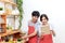 Attractive young asian couple or student looking at recipe and enjoy cooking food in kitchen at home. Man and woman in gen