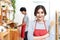 Attractive young asian couple wearing casual orange apron cooking meal in wooden kitchen at home or apartment. Young millennials