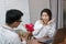 Attractive young Asian woman excited to get a bouquet of red roses in office on valentine`s day. Love and romance in workplace co