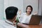 Attractive young Asian woman excited to get a white rose in office on valentine`s day. Love and romance in workplace concept.