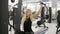 Attractive young blond caucasian woman with sporty body performing weightlifting on a lat pull-down mashine at the gym