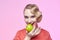 Attractive young blonde with a retro hairstyle is about to bite off a green apple