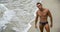 Attractive young bodybuilder in bathing suit on the beach