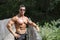 Attractive young bodybuilder outdoors, leaning