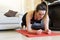 Attractive young brunette doing exercise at home while standing on a gym mat. Doing plank exercise. Homely environment