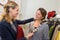 Attractive young brunette trying on necklace in jewelry store