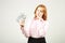 Attractive young businesswoman posing with bunch of USD cash in hands showing positive emotions and happy facial expression.