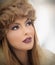 Attractive young Caucasian adult with brown fur cap. Beautiful blonde girl with gorgeous lips and eyes wearing fur hat, outdoor